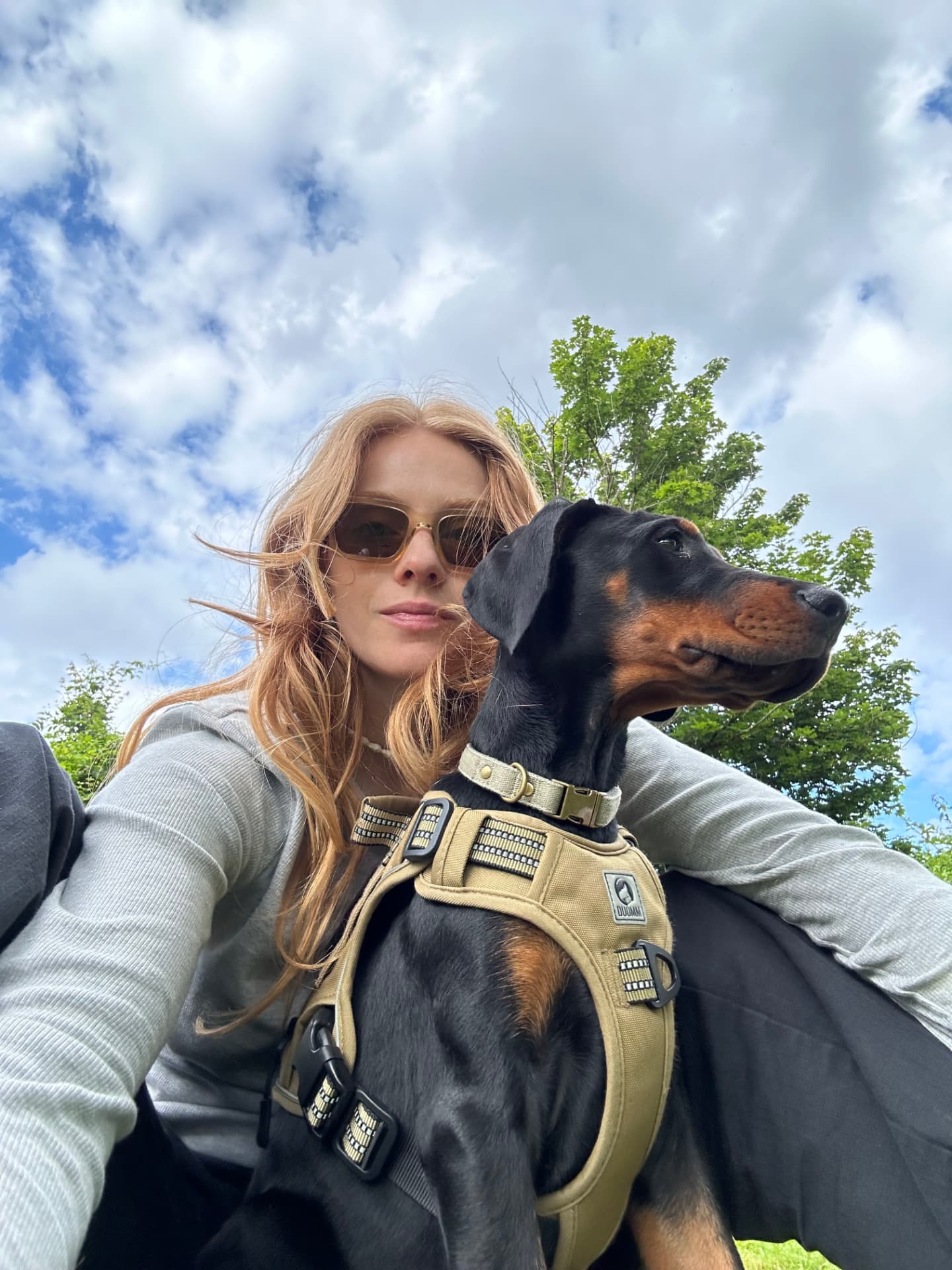 Clémence et Neva, sa Doberman, en pleine nature sous un ciel nuageux
